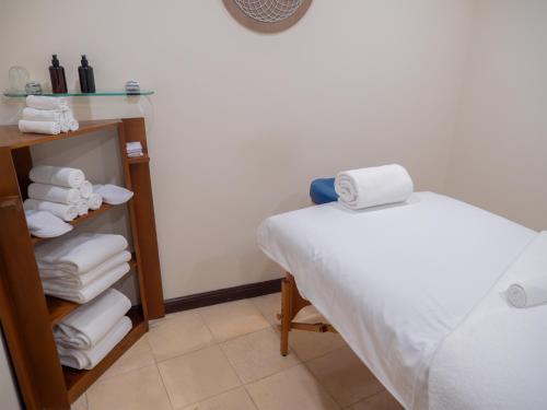 a room with a bed and a stack of towels at MS Milenium Monterrey Curio Collection by Hilton in Monterrey