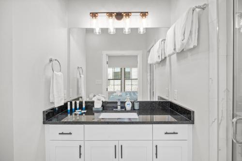 une salle de bain blanche avec un lavabo et un miroir dans l'établissement Eagle's Hub - Hot Tub 5 Min to Main, à Fredericksburg