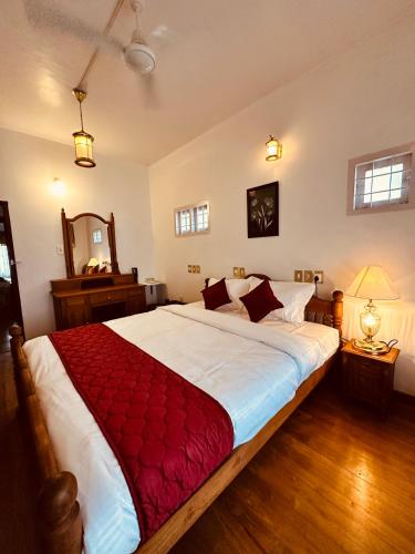 a bedroom with a large bed with a red blanket at Cleety's Residency in Cochin