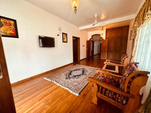 a living room with a couch and a tv at Cleety's Residency in Cochin