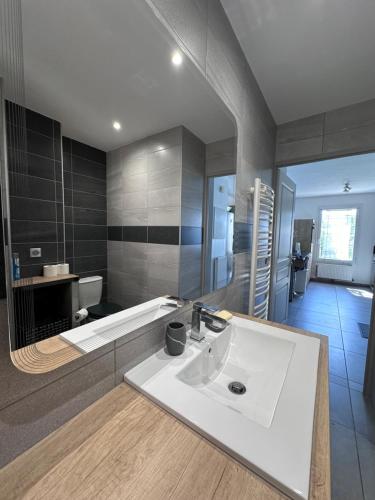 La salle de bains est pourvue d'un lavabo blanc et d'une baignoire. dans l'établissement Hameau de tranquillité, à Gap