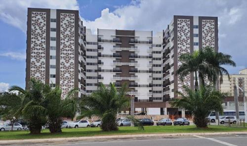 a large apartment building with cars parked in a parking lot at Spazzio diRoma com acesso ao Acqua Park - Temporada CN in Caldas Novas
