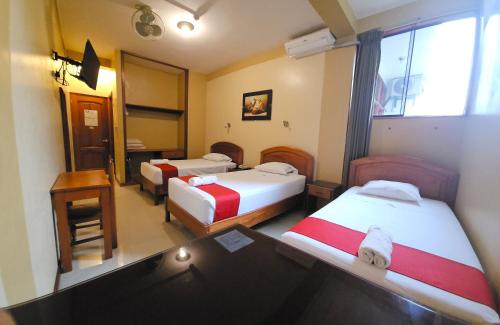 a hotel room with two beds and a window at Hotel Centenario in Puerto Maldonado