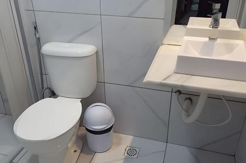 a bathroom with a white toilet and a sink at Residencial JC II sua casa em Belém do Pará in Belém