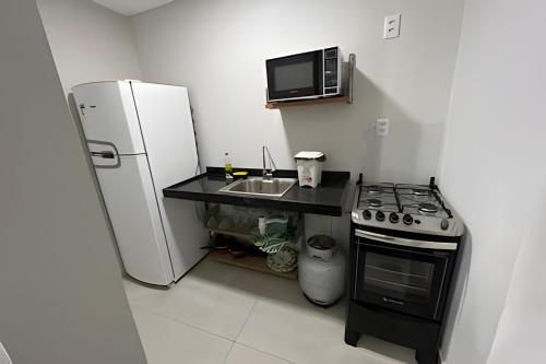 a small kitchen with a refrigerator and a sink at Residencial JC II sua casa em Belém do Pará in Belém