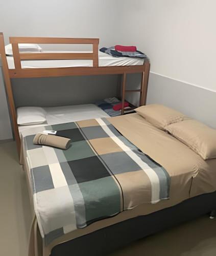 a bed with a checkered blanket on top of it at Residencial JC II sua casa em Belém do Pará in Belém
