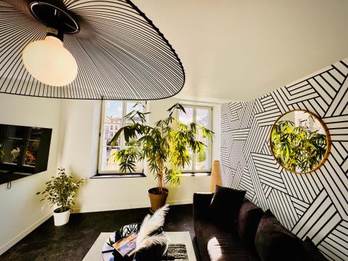 ein Wohnzimmer mit einer Couch und einer Pflanze in der Unterkunft Epinappart avec terrasse in Épinal
