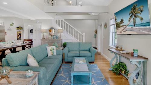 a living room with two blue couches and a table at The Pirates Penthouse by Last Key Realty in Key West