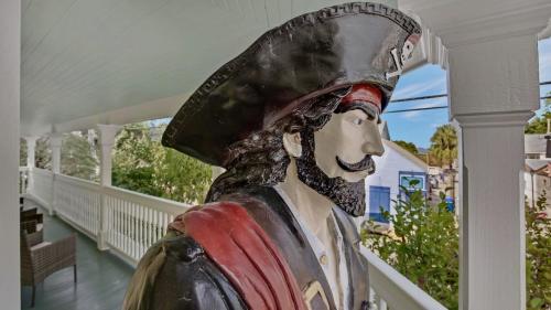 a statue of a man wearing a hat on a porch at The Pirates Penthouse by Last Key Realty in Key West