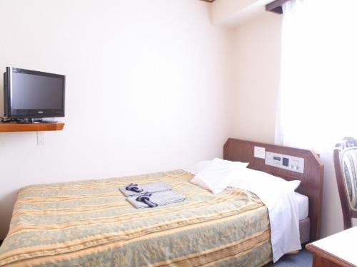 a bedroom with a bed with a tv on the wall at Terminal Art Inn - Vacation STAY 97356v in Niigata