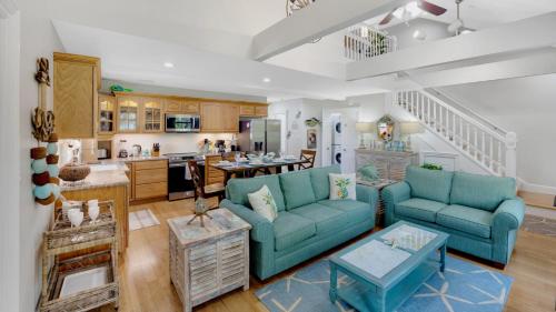 a living room with two blue couches and a kitchen at The Pirates Penthouse by Last Key Realty in Key West
