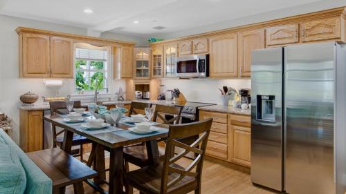 a kitchen with a table and a stainless steel refrigerator at The Pirates Penthouse by Last Key Realty in Key West