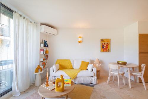 un salon avec un canapé blanc et une table dans l'établissement Charmant studio à Mougins, à Mougins