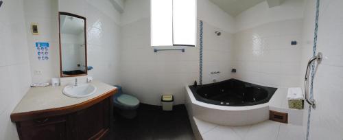 a bathroom with a large tub and a sink and a tub at Hotel Centenario in Puerto Maldonado