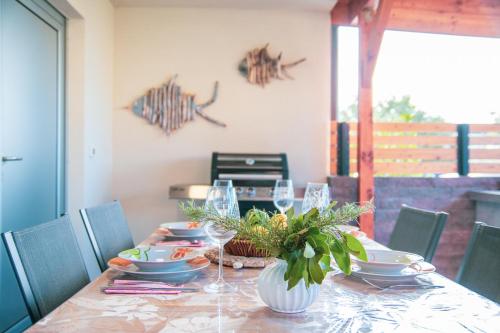 a table with plates and wine glasses on it at Apartment Maja Medulin in Medulin