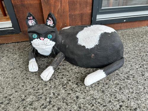 a black and white cat statue sitting on the floor at Eagle Way in Port Renfrew