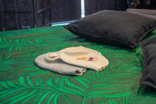 a towel and pillow on a bed with a green blanket at Apartments in Kaunas city centre with Jacuzzi bath in Kaunas