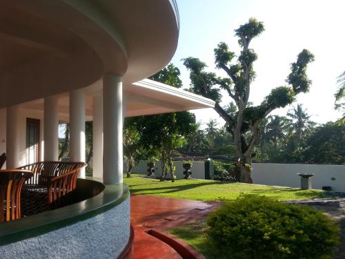 a porch of a house with chairs and a yard at Ahangama Eco Villa in Ahangama