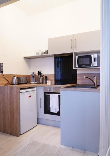 a kitchen with a sink and a stove top oven at Le Repos du Tertre in Chartres