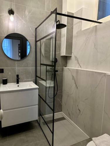 a bathroom with a shower and a sink and a mirror at Le Repos du Tertre in Chartres