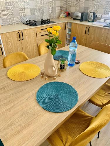 a wooden table with yellow plates and a vase with yellow flowers at Sunny Side Up - Private 3BR villa with pool in Grand Baie