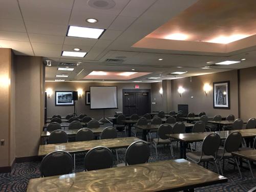 a conference room with tables and chairs and a screen at Best Western Plus Kingston Hotel and Conference Center in Kingston