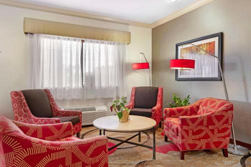 a living room with red chairs and a table at Best Western Plus Eagleridge Inn & Suites in Pueblo