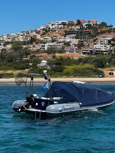 a speed boat in the water with a city in the background at Thedreamlifehouse in Anavissos