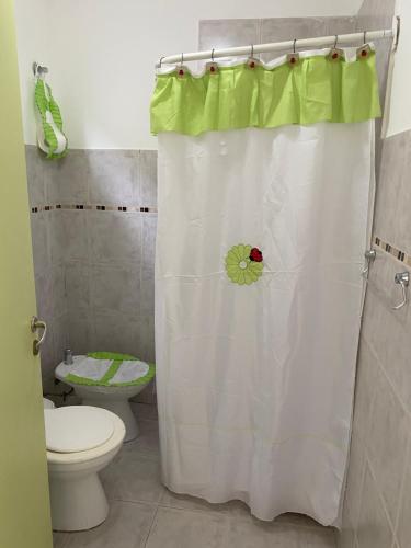 a bathroom with a toilet and a shower curtain at Casita María in Puerto San Julián