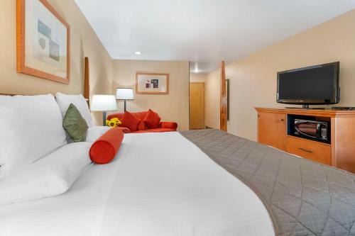a hotel room with a large white bed and a flat screen tv at Best Western Prineville Inn in Prineville