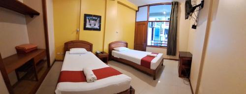 a small room with two beds and a window at Hotel Centenario in Puerto Maldonado