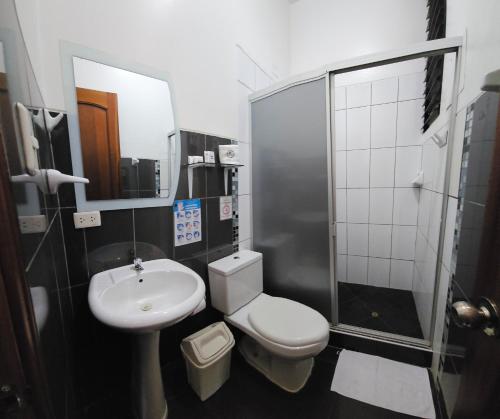 a bathroom with a toilet and a sink and a shower at Hotel Centenario in Puerto Maldonado