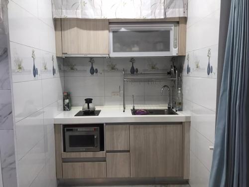 a small kitchen with a sink and a microwave at Old Chen Outdoors in Chaozhou