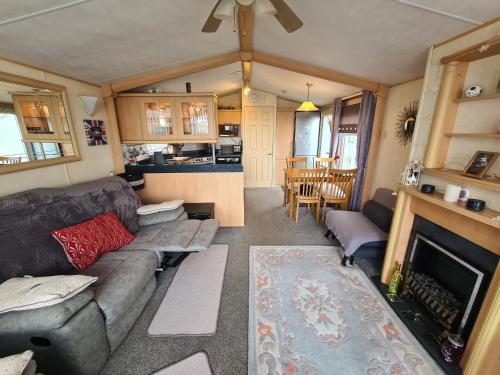 a living room with a couch and a fireplace at 5 Berth Family Caravan Ingoldmells in Skegness