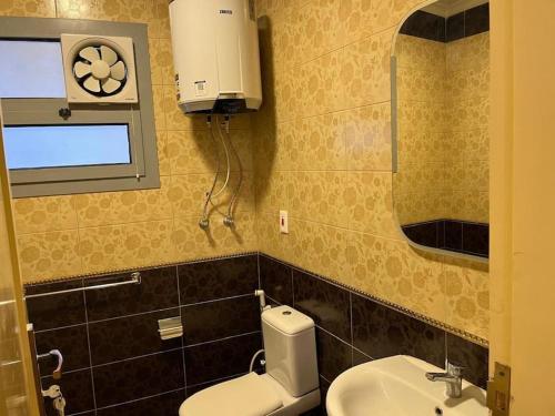 a bathroom with a toilet and a sink and a mirror at Comfort Plaza A in Cairo