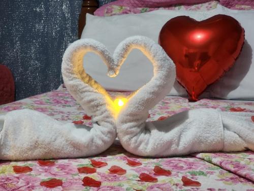 two towels shaped like hearts sitting on top of a bed at Pousada o Canto da Seriema in Nobres