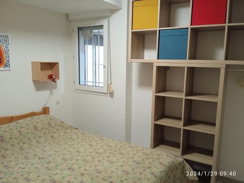 - une chambre avec un lit, des étagères et une fenêtre dans l'établissement Vacances Idéale en Bord de Mer, à Marseillan