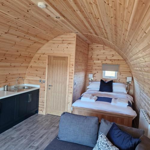 a bedroom with a bed in a wooden room at Milldown Glamping in Coldingham