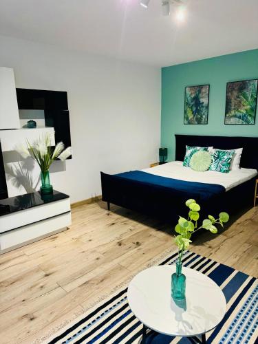 a room with a bed and a table in it at Blue Apartment close to Old Town in Bydgoszcz
