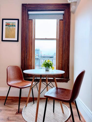 a table and two chairs in a room with a window at Copley House in Boston