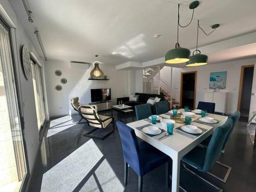 a dining room and living room with a table and chairs at Villa Turquesa un lugar único in Alicante