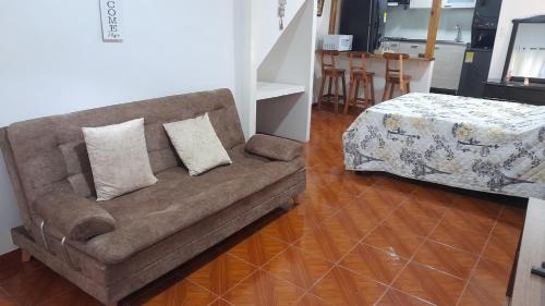 a couch with two pillows in a living room at 2 beautiful Apartments in Downtown Risaralda Caldas 1 studio and 1 full apartment in Rizaralda