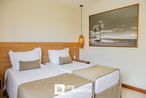 two beds in a hotel room with a picture on the wall at Ponta de Inhambupe Residences in Baixio