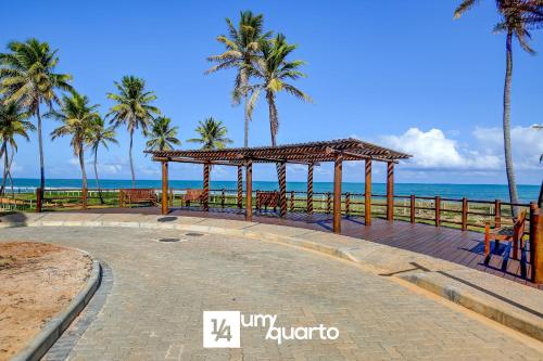 a pavilion on a beach with palm trees and the ocean at Ponta de Inhambupe Residences in Baixio
