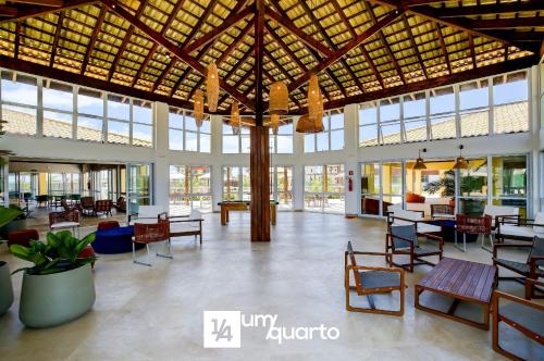 a large lobby with tables and chairs and windows at Ponta de Inhambupe Residences in Baixio