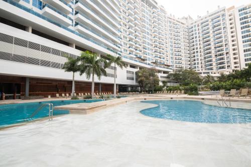 an empty swimming pool in a building with tall buildings at Apartamentos Luxury Frente al Mar - AR Rentals in Gaira