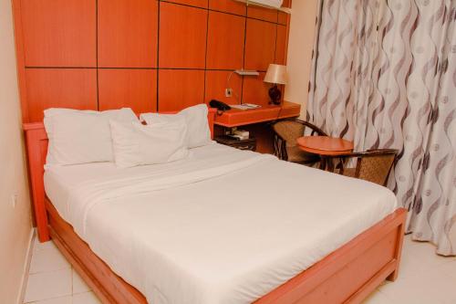 a bedroom with a large bed with a desk and a bed sidx sidx at Royal Village Dodoma in Dodoma