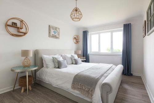 une chambre avec un lit blanc et une fenêtre dans l'établissement Braganza The Butler Collection, à Middleton-on-Sea