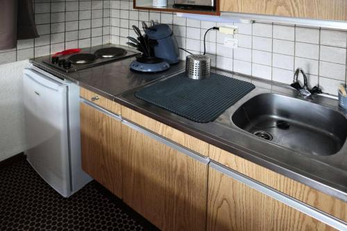 une cuisine avec un évier et un plan de travail dans l'établissement Résidence Le Pouzenc - Studio 6 personnes accès direct aux pistes MAE-3921, aux Orres