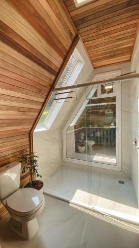 a bathroom with a toilet and a window at Cabana Snowflake Urubici in Urubici